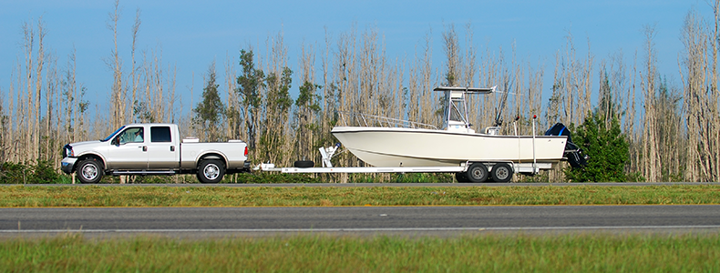 white truck hauling a boat on open road
