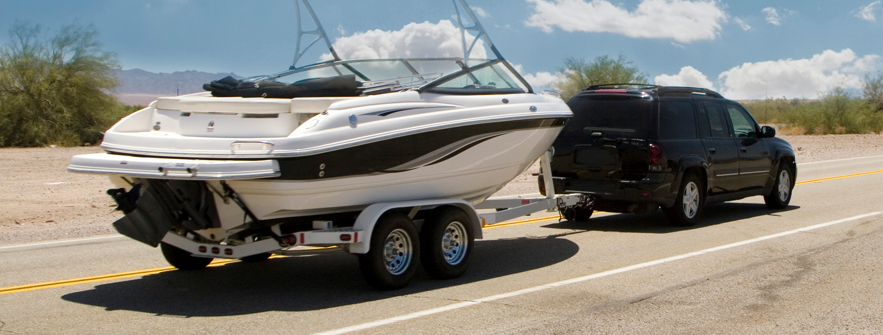 black SUV towing a boat as a boat transporter