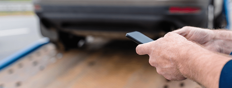 Person managing their vehicle shipping service via their phone.