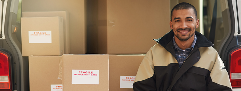 man in front of household goods ready for shipping