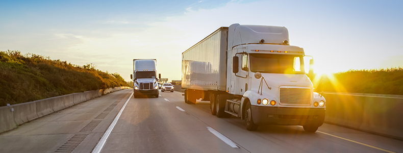 two LTL freight trucks on the road