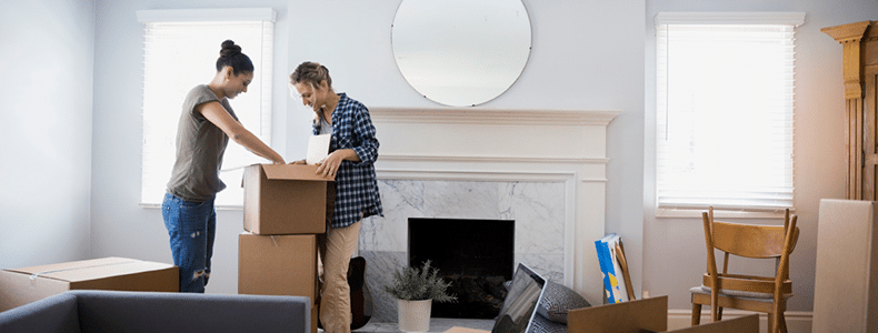 couple packing boxes for international move
