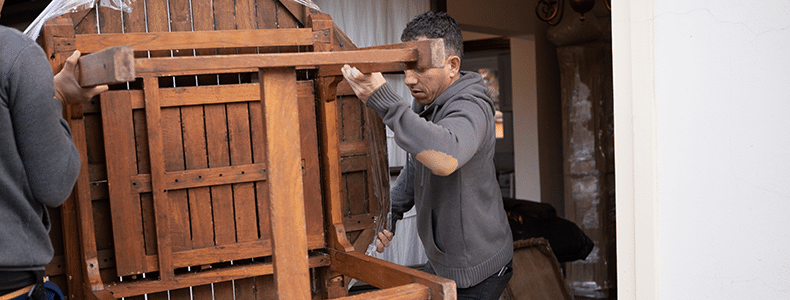 movers carrying patio furniture to a home